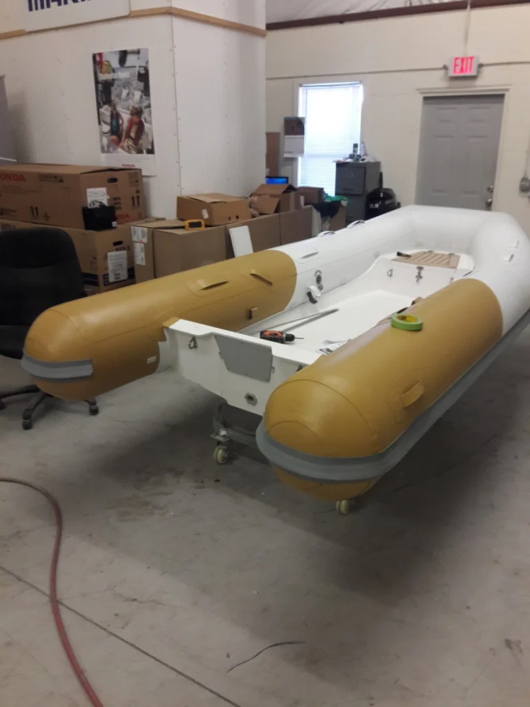 Beige inflatable tender with a custom console base in the Fair Winds shop