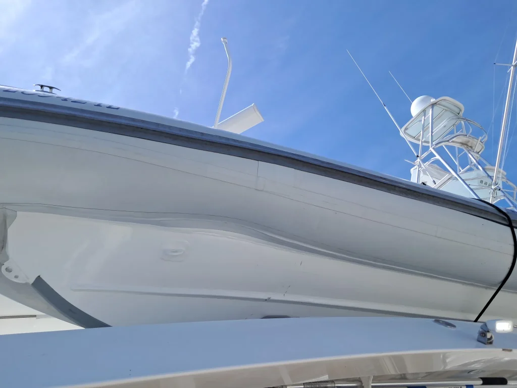 White inflatable boat hull viewed from below outside the workshop